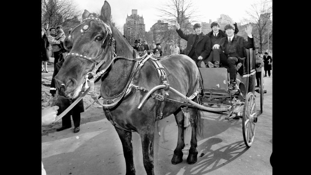 Three of The Beatles -- from left, Ringo Starr, Paul McCartney and John Lennon -- wave from a horse-drawn carriage in New York's Central Park on February 8, 1964. George Harrison was off resting a sore throat.