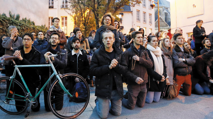 “제발 무사하길” 기도하는 파리 시민들 - 15일(현지 시각) 화염에 휩싸인 노트르담 대성당 앞에 모인 시민들이 무릎을 꿇고 불길이 잡히기를 기도하고 있다.
