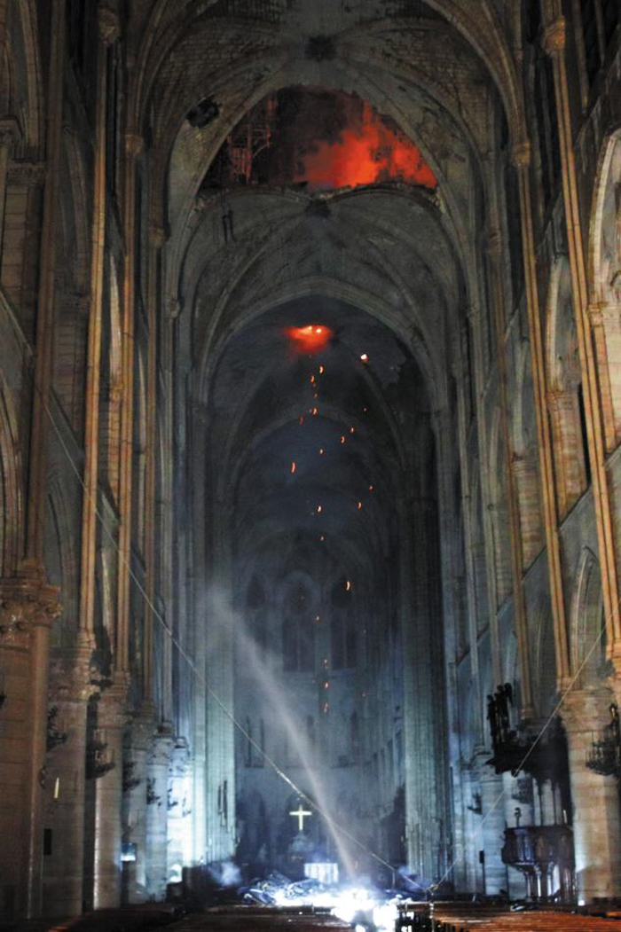 폭격 맞은듯 뻥 뚫린 천장 - 15일(현지 시각) 프랑스 파리 노트르담 대성당의 천장에 뚫린 구멍에서 시뻘건 불똥이 떨어져 날리고 있다. 소방호스에서 물이 뿜어져 나오고 있지만 천장 불길에 닿기엔 역부족이다. 8시간 넘게 이어진 화재로 노트르담 대성당은 지붕이 전소되고 첨탑이 무너지며 크게 훼손됐다.
