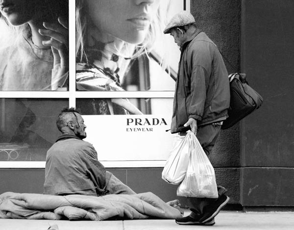 미국 캘리포니아주 로스앤젤레스시의 한 명품 매장 쇼윈도우 앞에서 노숙인이 행인과 이야기를 나누고 있다. / Photo by Max Bohme on Unsplash 