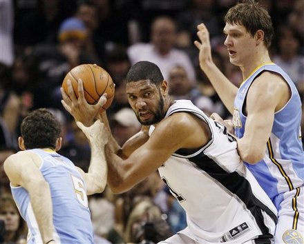 San Antonio Spurs' Tim Duncan, Center, Drives Between Denver Nuggets' Rudy Fernandez, Left, Of Spain, And Timofey