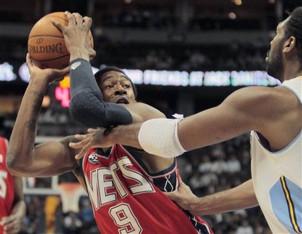 New Jersey Nets Guard MarShon Brooks (9) Tries To Back Out Of The Reach Of Denver Nuggets Center Nene Hilario (31), Of