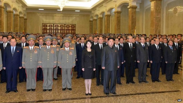 North Korean leader Kim Jong-un, his wife, and high ranking officials stand together in front of statues of the late North Korean leaders, Kim Il-sung and Kim Jong-il in Pyongyang, North Korea, 17 December 2013