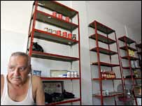 A Lebanese man sits in a shop nearly depleted of food supplies in Tyre