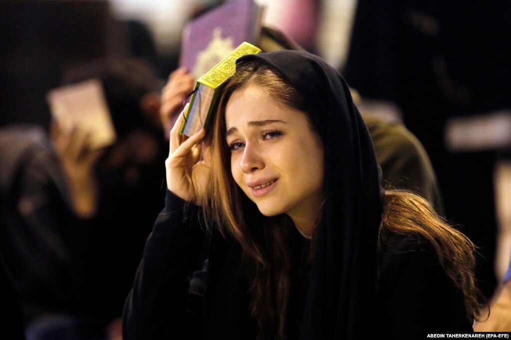 An Iranian Shi'ite Muslim woman prays as she places the Koran on her head during a religious ceremony during the holy fasting month of Ramadan, at the Mosalah mosque in Tehran.