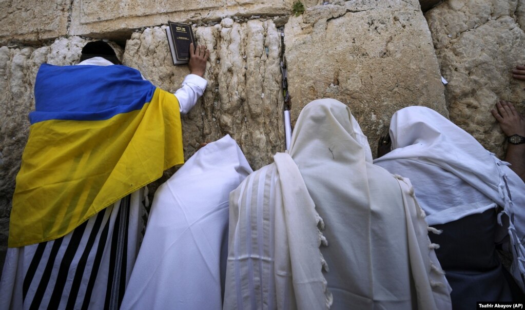 An ultra-Orthodox Jewish man wrapped in a Ukrainian flag is seen during the Jewish holiday of Passover at the Western Wall in Jerusalem's Old City.