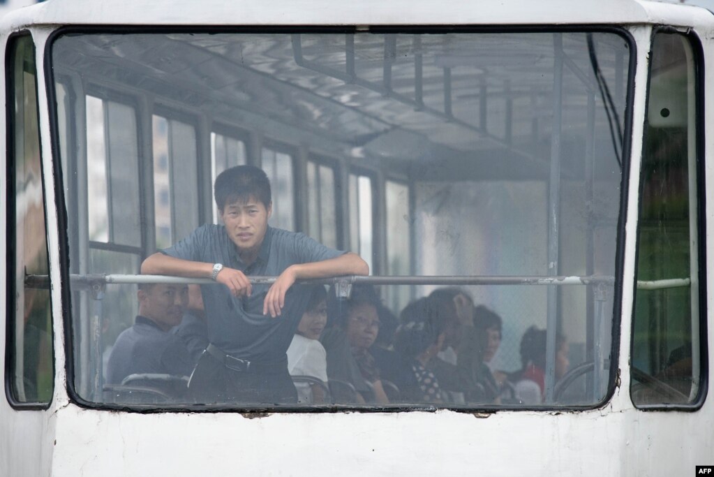 북항 평양에서 남성이 출근길 트램을 타고 있다.