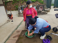 어르신의 발을 씻겨드리는..