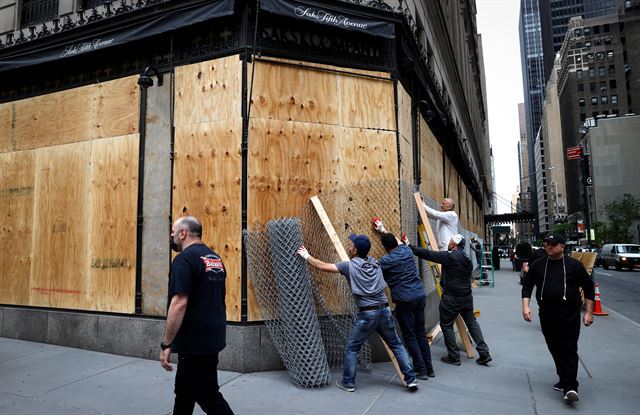 약탈을 막기 위해 판자를 설치하는 미국 뉴욕의 쇼핑가
