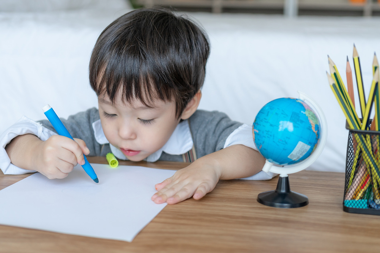 little-boy-joyful-with-use-orange-pencil-color-drawing-on-white-paper.jpg