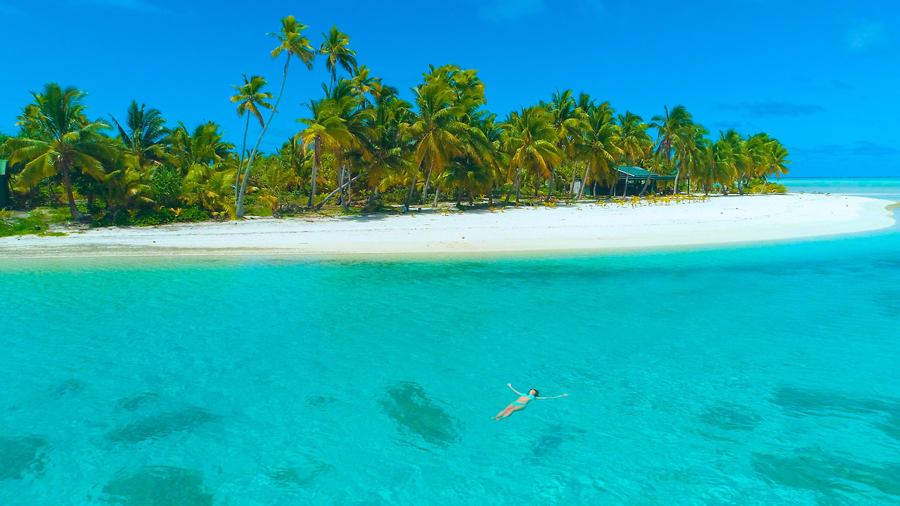 AERIAL Carefree girl on vacation swimming on her back near the tropical.jpg