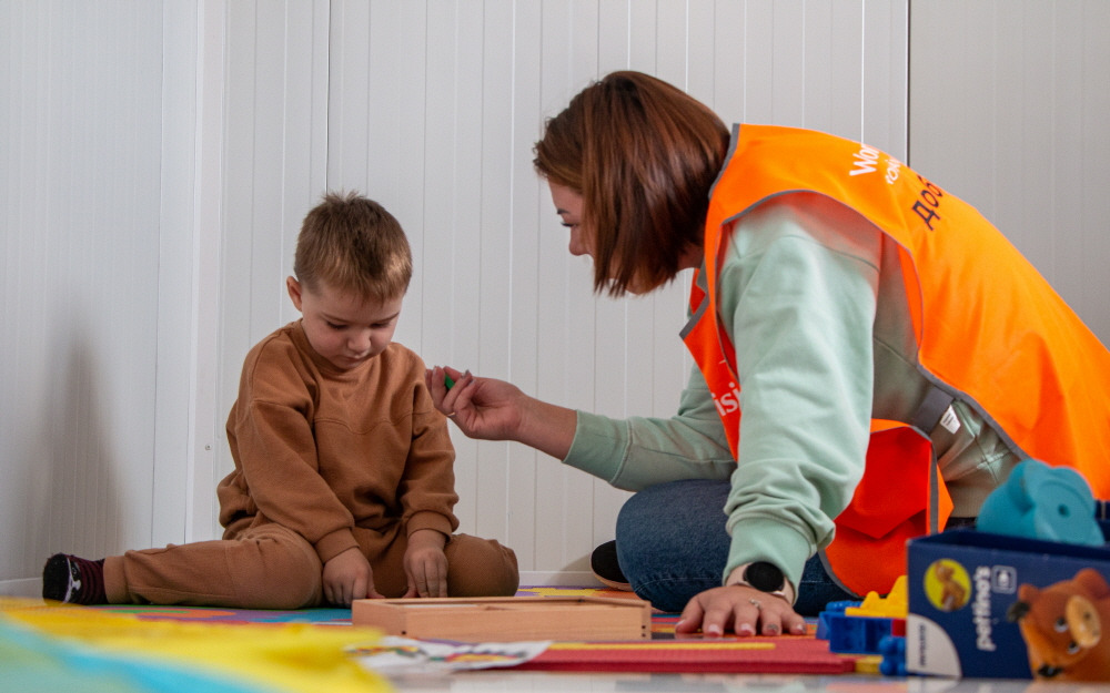 [이미지자료] 루마니아 부쿠레슈티의 월드비전 아동친화 공간에서 우크라이나월드비전 봉사자의 보호를 받고 있는 마리트(3살)의 모습.jpg