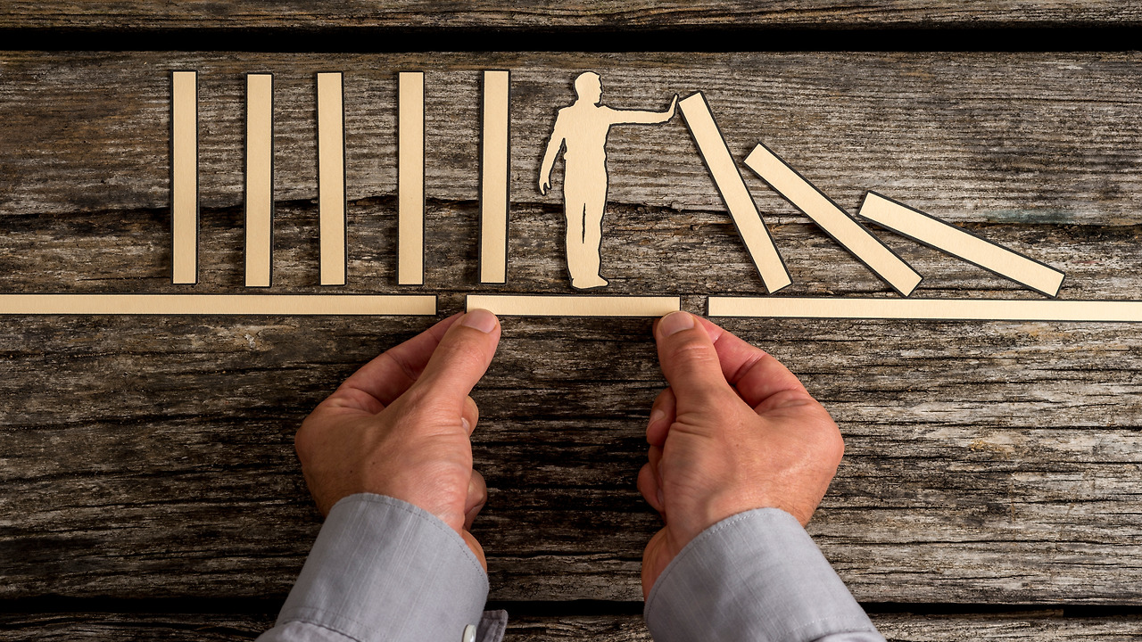 businessman-stopping-the-domino-effect-PLZSX95.jpg