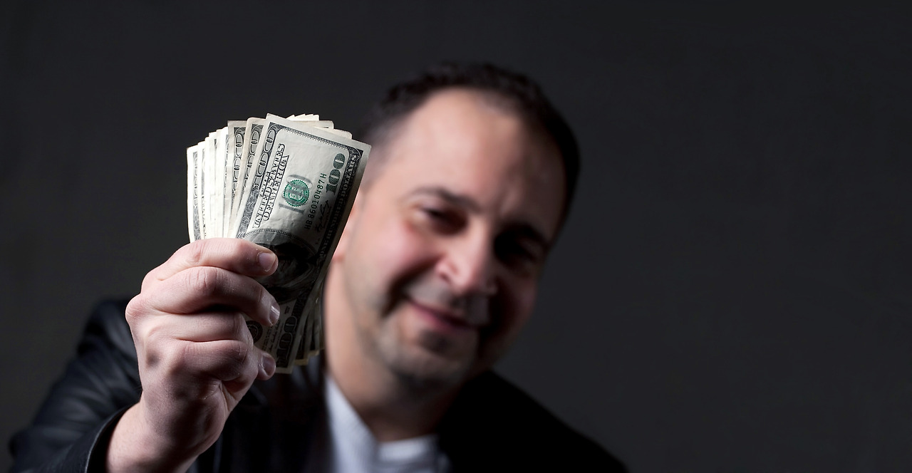 a-happy-middle-aged-man-holding-a-handful-of-money-with-copyspace_rKNk5w0Bs.jpg