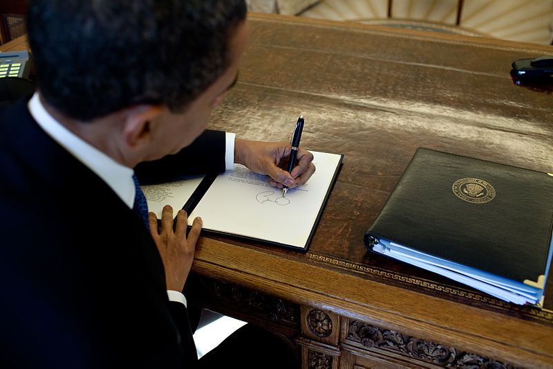800px-Barack_Obama_signs_at_his_desk.jpg