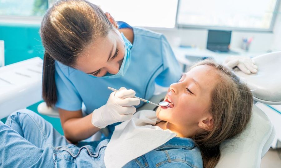 Young-girl-sitting-on-dental-chair-getting-her-teeth-checked-by-a-dentist-thegem-blog-default.jpg