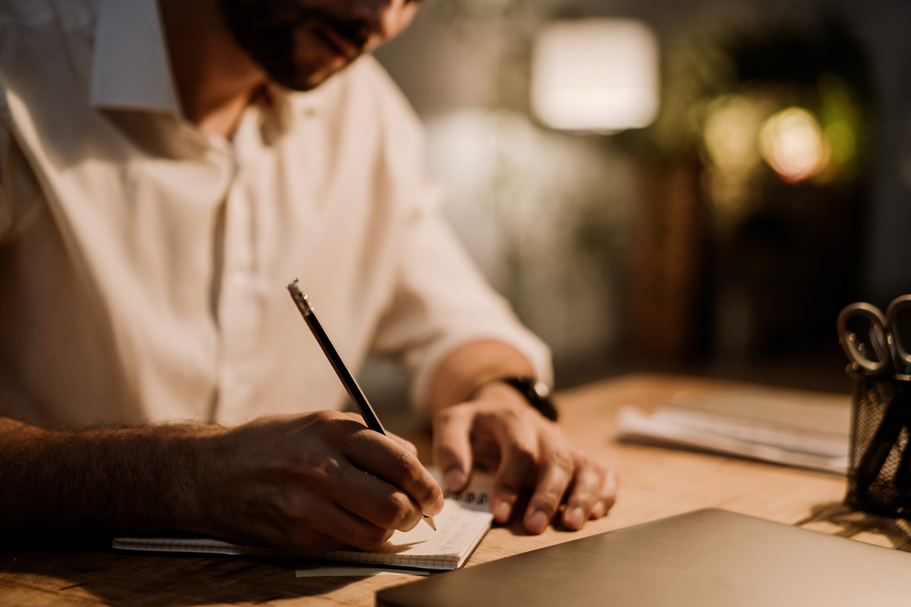 white-man-writing-down-notes-in-planner-while-work-2023-11-27-05-23-28-utc.jpg
