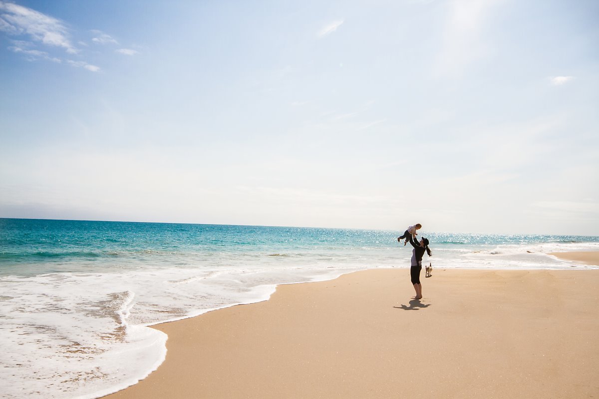 Mother_throwing_baby_into_the_air_at_the_beach_-625974278.jpg