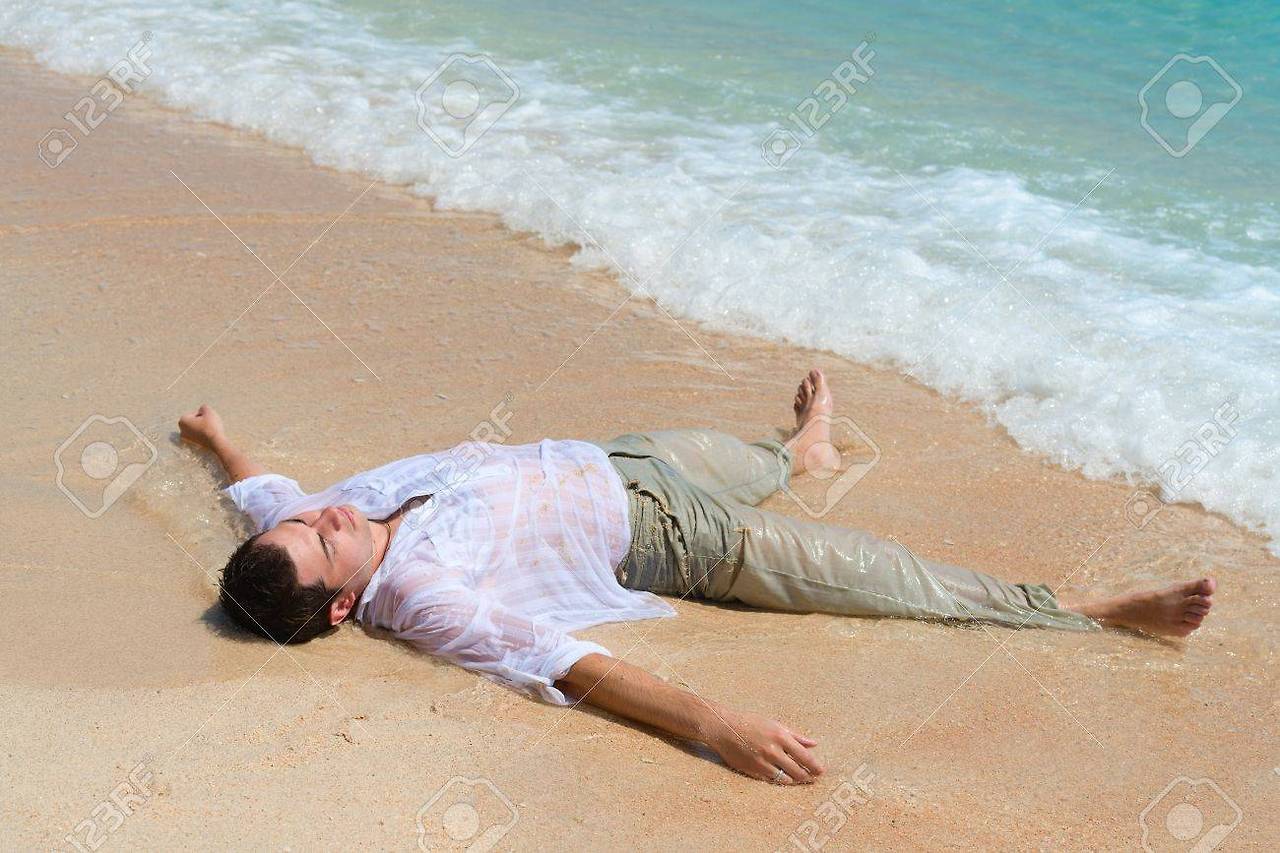 21362010-tired-out-man-lie-on-sandy-beach-near-the-blue-sea.jpg