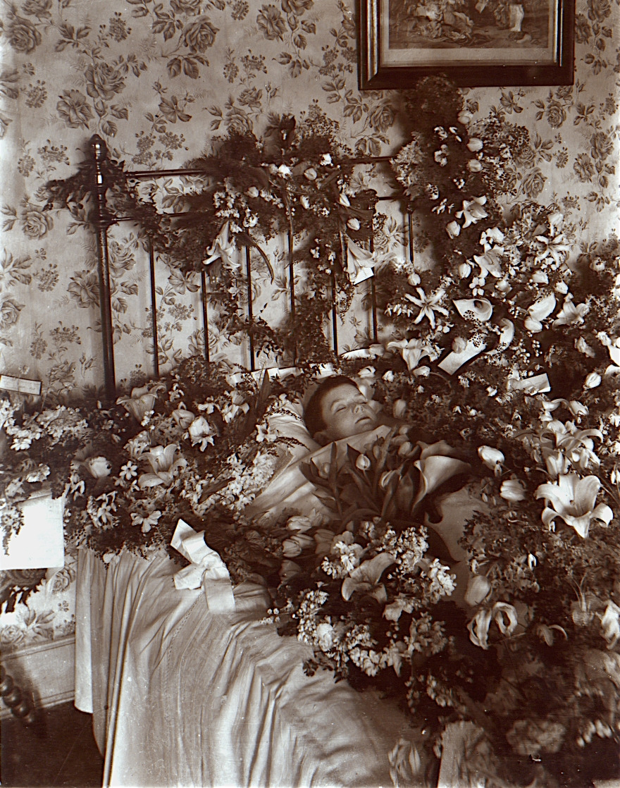 Post-mortem_photograph_of_young_child_with_flowers.jpg