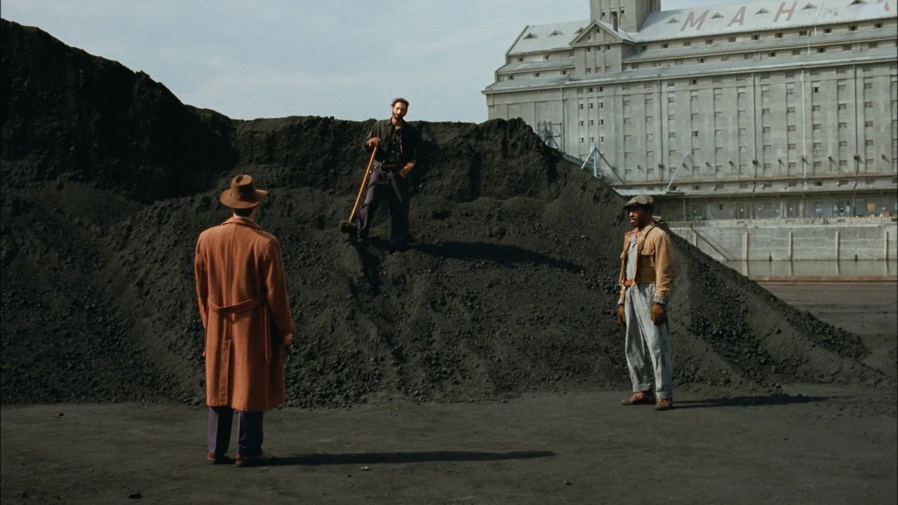 a-man-stands-in-a-mountain-of-dirt-while-two-others-speak-to-him-in-the-film-the-brutalist.jpg