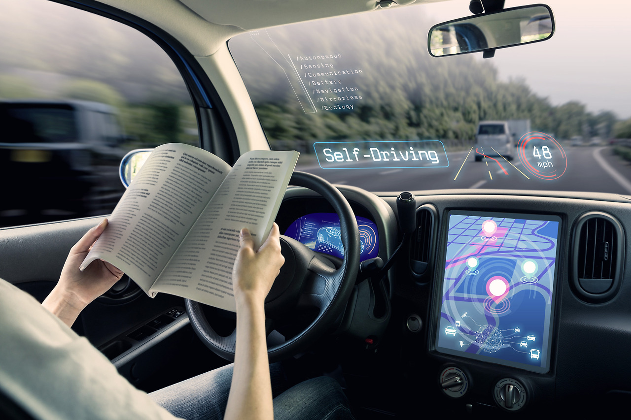 vehicle-running-self-driving-mode-and-a-woman-driver-reading-book.jpg
