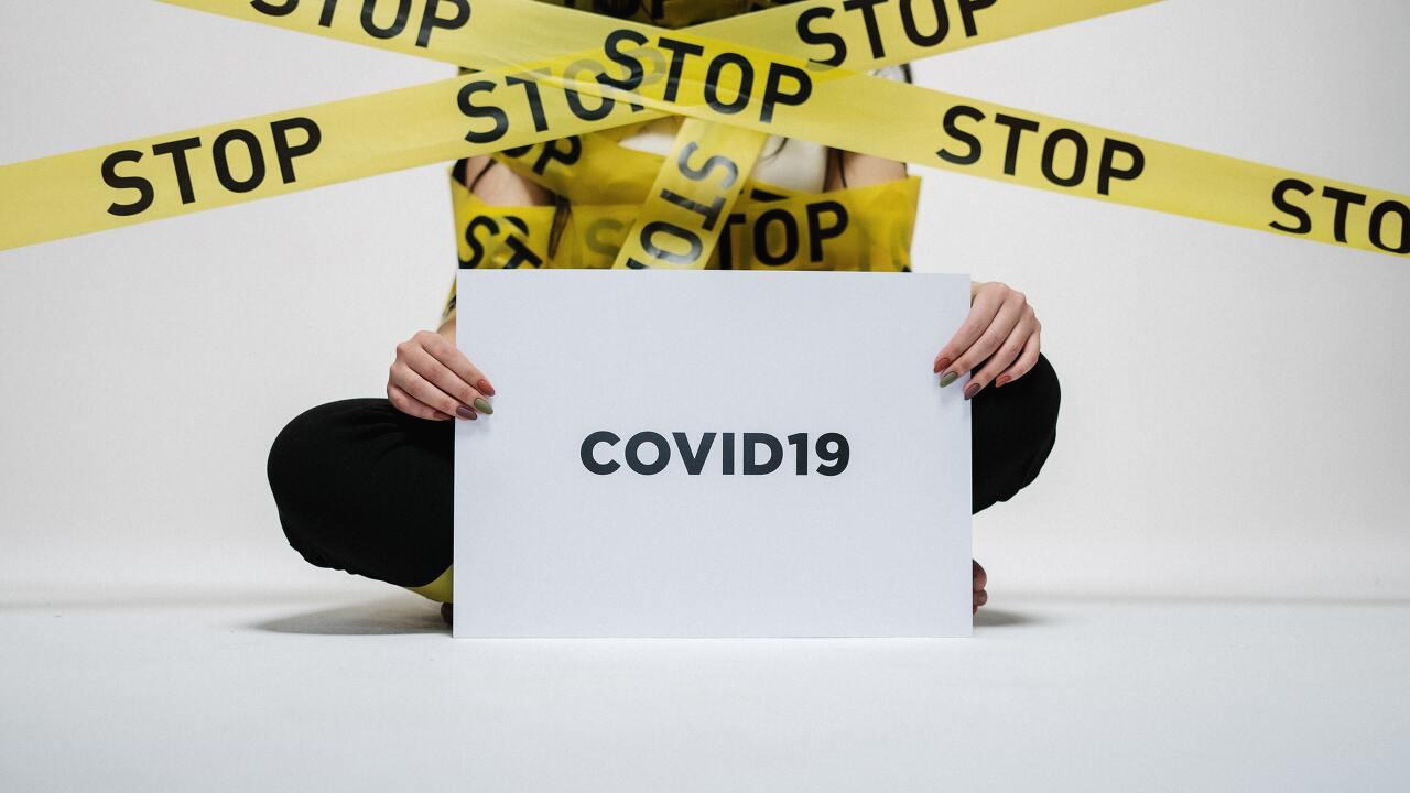 person-holding-covid-sign-3951600.jpg
