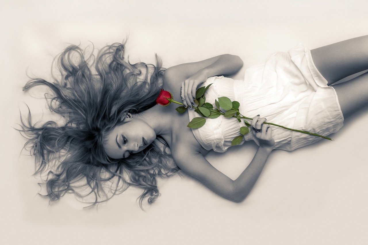 studio-shot-of-beautiful-woman-lying-on-back-and-holding-rose.jpg