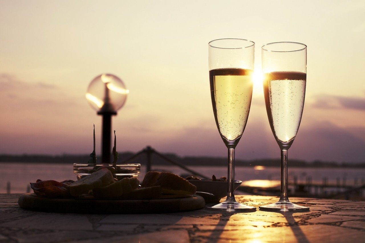 champagne-flutes-and-cheese-on-cutting-board-on-ledge-at-sunset.jpg