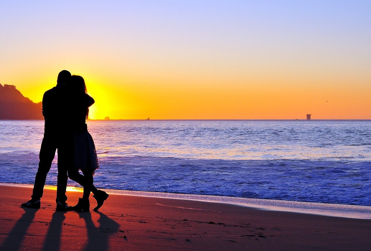 silhouette-of-couple-embracing-on-beach-at-sunset.jpg