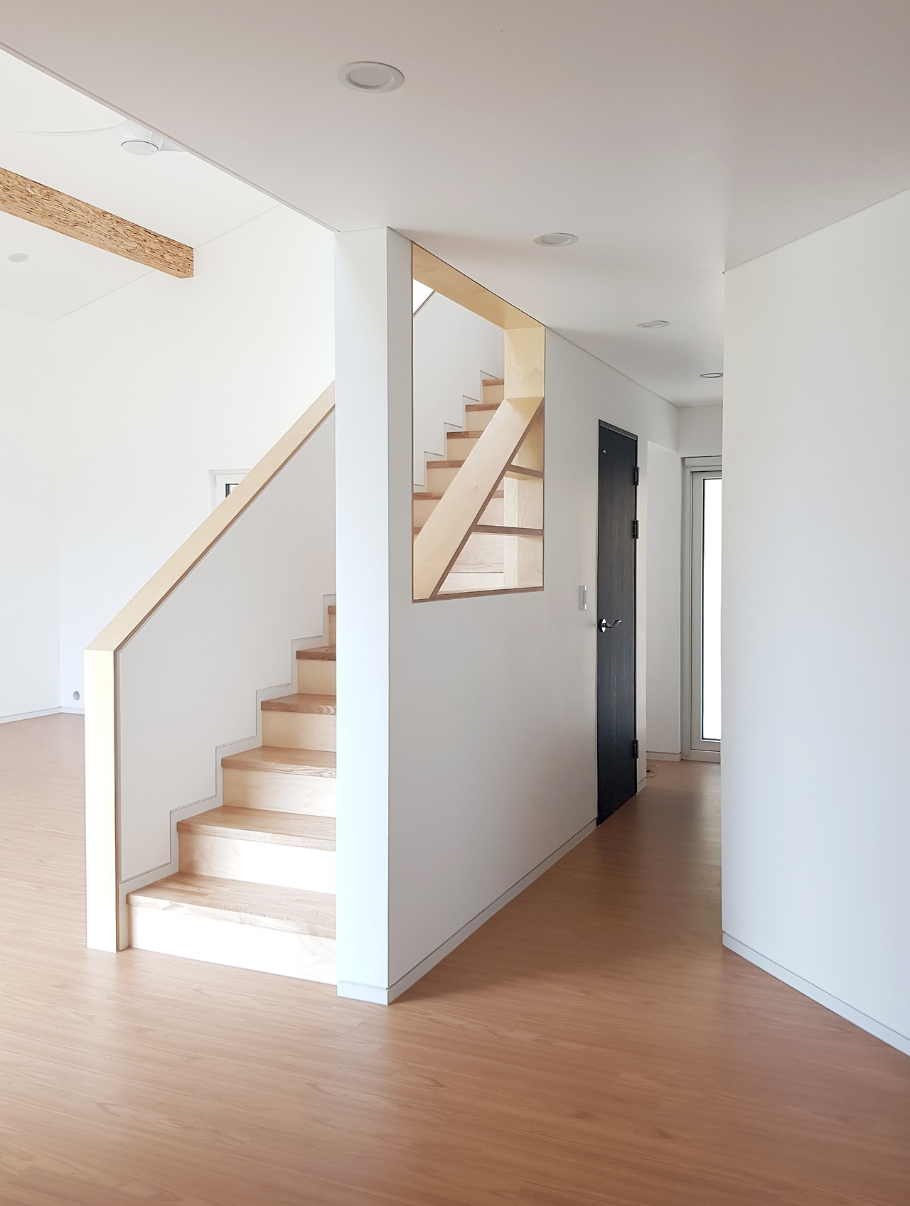 010.거실에 다다르기 전 1층 복도 모습_오브제 같은 계단공간이 거실-욕실-후정으로 이르는 동선을 자연스럽게 나눈다.jpg