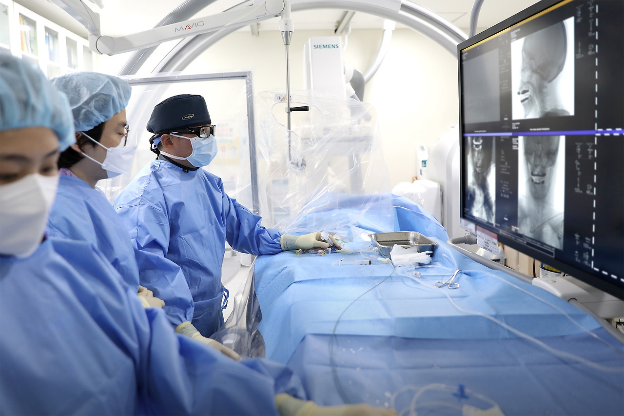 [사진] 일산백병원 구해원 교수가 뇌동맥류 환자에게 코일색전술을 시행하고 있는 모습. 특수 영상장비를 활용해 뇌혈관 내 미세도관을 삽입한 뒤, 동맥류 내부에 백금 코일을 삽입해 혈류를 차단하는 고난도 시술이다..jpg