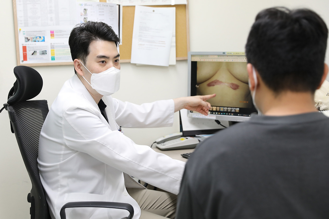 [사진] 이충현 일산백병원 성형외과 교수가 켈로이드 흉터 원인과 치료법에 관해 환자에게 설명하고 있다. - 복사본.jpg