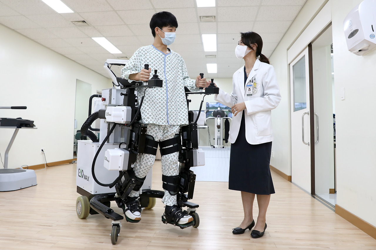 [사진]유지현 재활의학과 교수가 외골격형 재활 로봇을 활용한 로봇 보행 치료 방법을 설명하고 있다_1.jpg