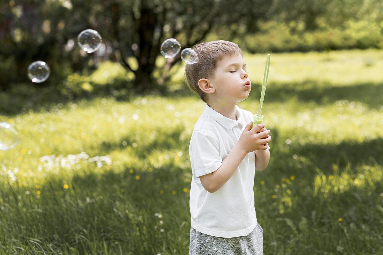 cute-child-blowing-bubbles-with-his-toy.jpg