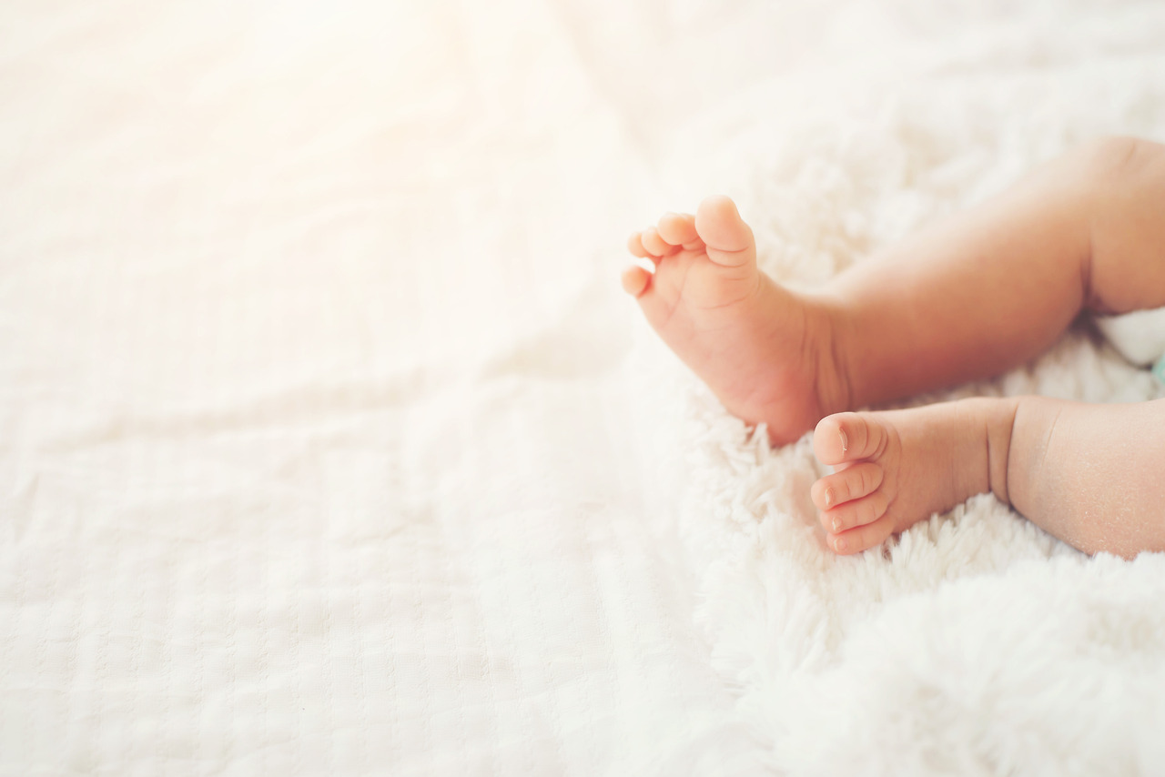 newborn-baby-legs-on-white-bed.jpg