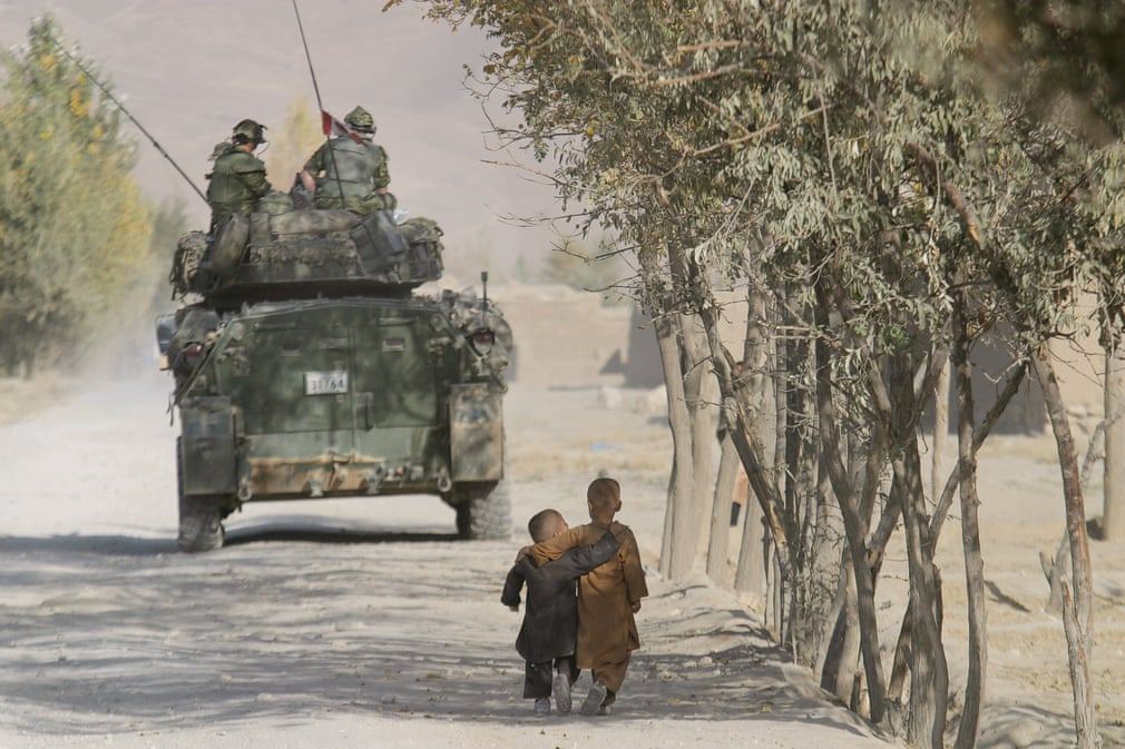 17 09 2021 Kabul, 2003. Afghan boys walk along a path while International Security Assistance Force troops guard the perimeter of a school in Shakadara province. 15 09 2021.jpg