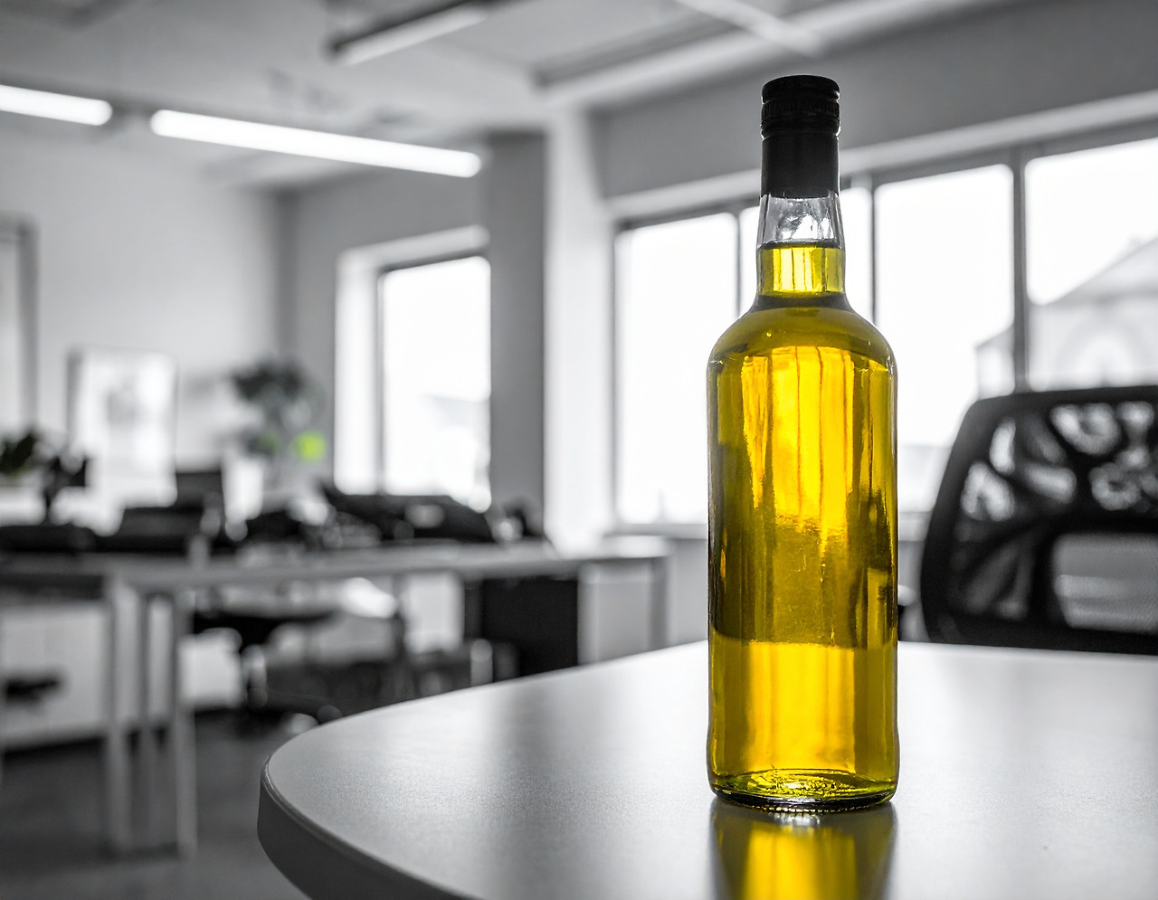Firefly Draw a picture of a bright yellow whiskey bottle on a table inside a black-and-white office. (1).jpg