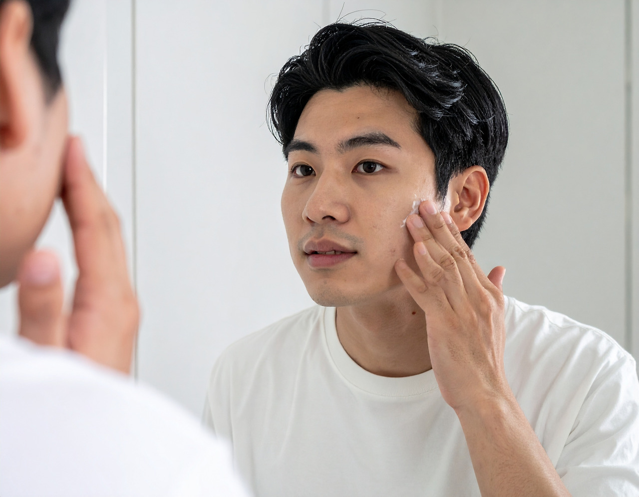 Firefly_A Korean man in his late 20s is looking in the mirror and applying lotion to his face 356578.jpg