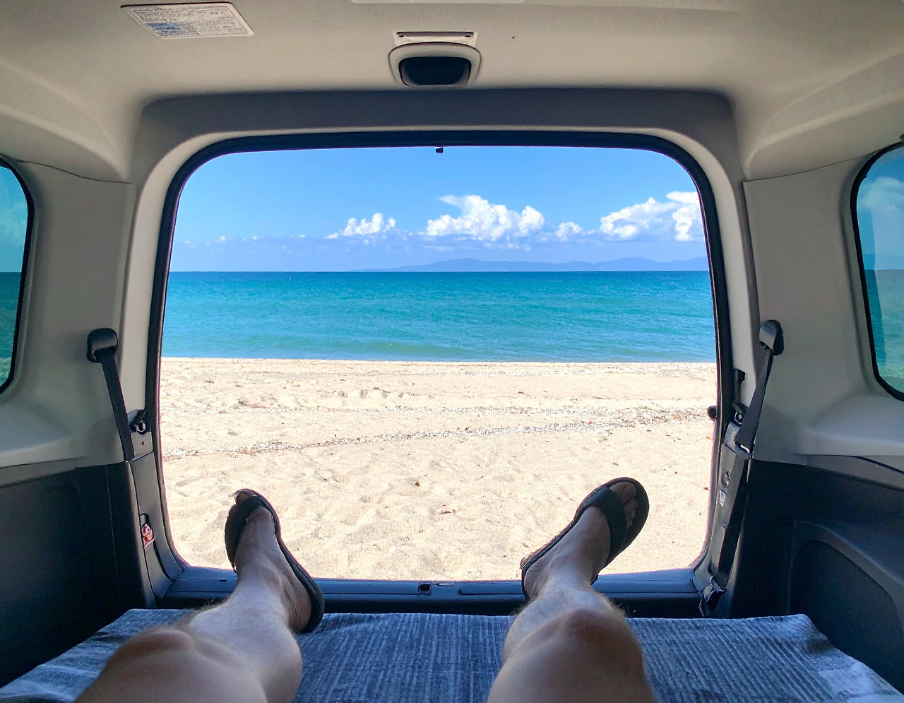 Firefly_I open the SUV trunk door and sit in the back, looking out at the beach with the blue 447965.jpg