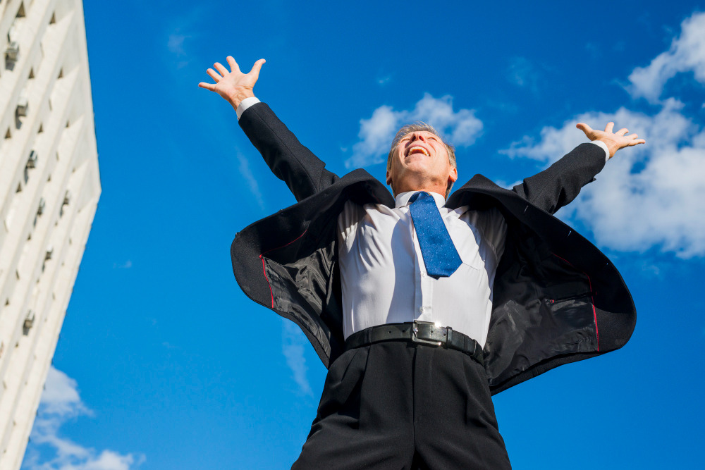 excited-businessman-raising-his-arms-against-sky (2).jpg