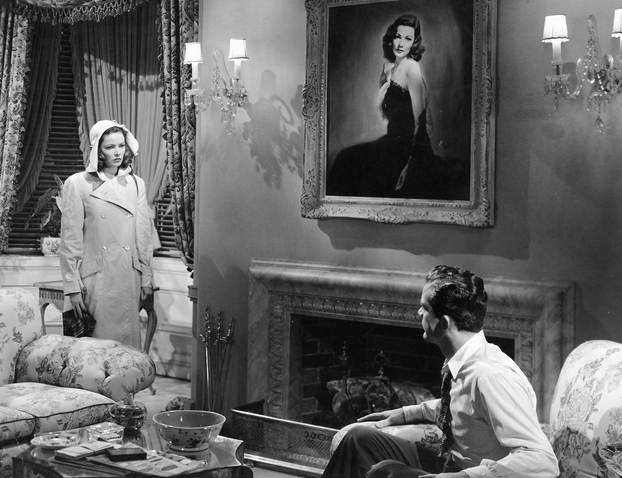 laura-1944-dana-andrews-gene-tierney-next-to-fireplace-with-enormous-painting-on-top.jpg