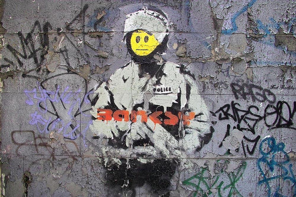 Banksy_Smiley_Riot_Cop_Wall_Mural_Wallpaper_a_1400x.jpg