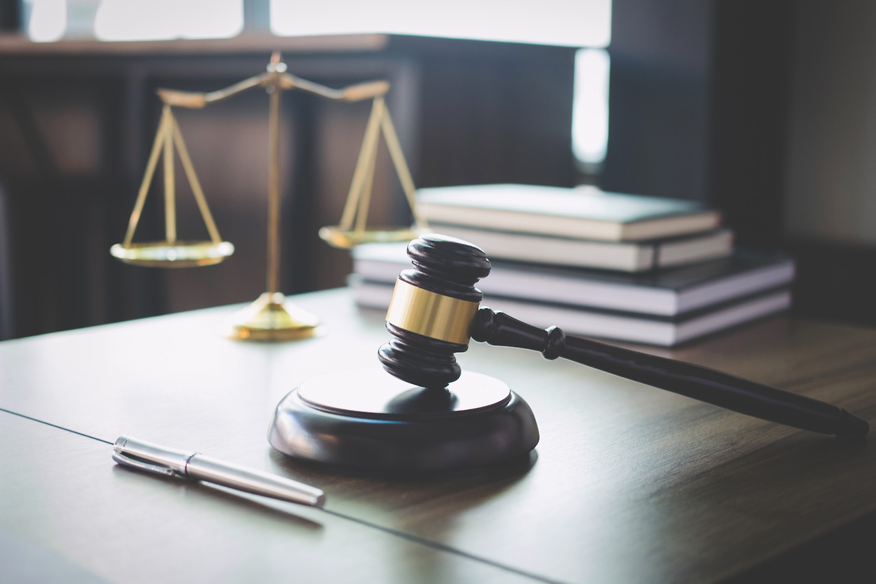 vecteezy_scales-of-justice-and-gavel-on-wooden-office-table_1241423.jpg