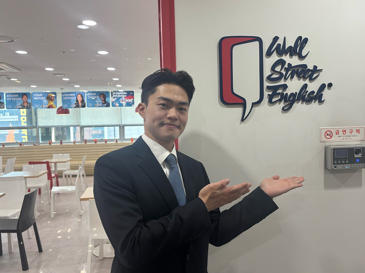 수강후기_윤재환님 1-1.문 앞 미소 로고 가리키는 상반신.jpg