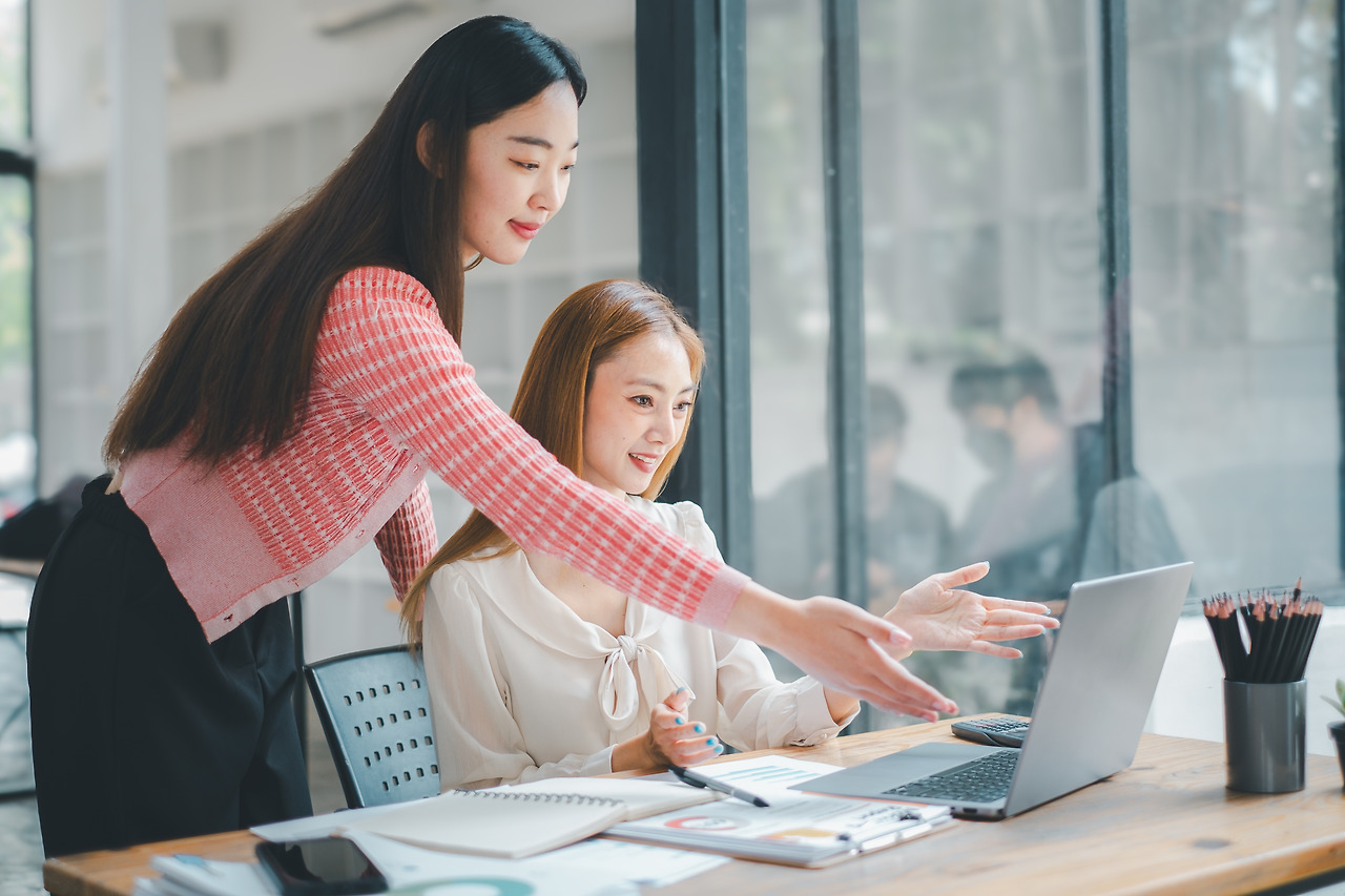 business-team-analytics-concept-two-female-colleagues-engaging-productive-discussion-laptop-welllit-modern-office-environment.jpg