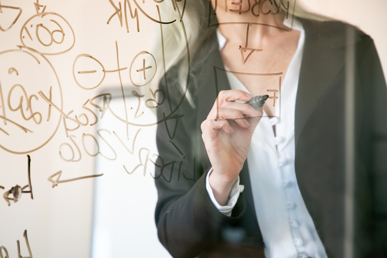 unrecognizable-grey-haired-businesswoman-writing-glass-board-hand-holding-black-marker-making-notes-project-strategy-business-management-concept.jpg