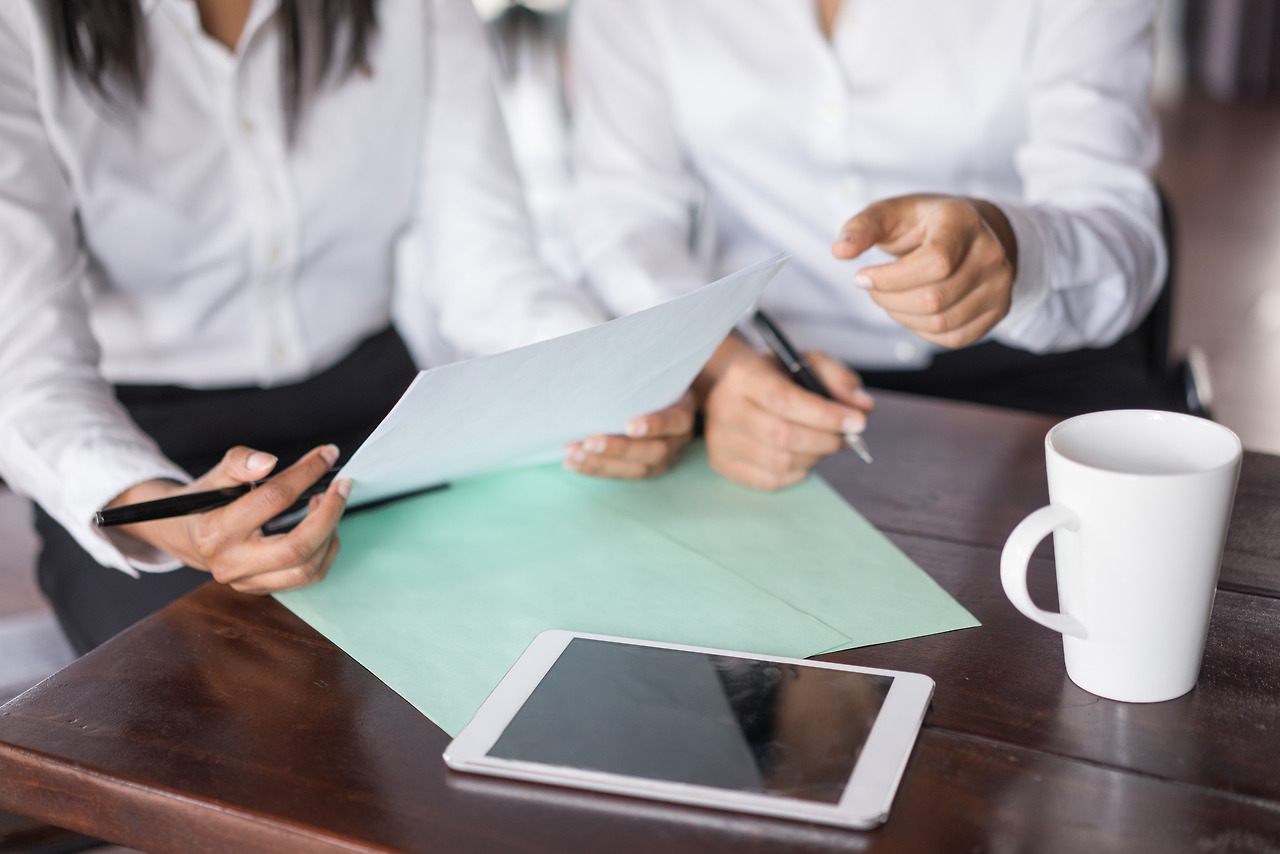closeup-two-female-colleagues-working-with-documents-table.jpg