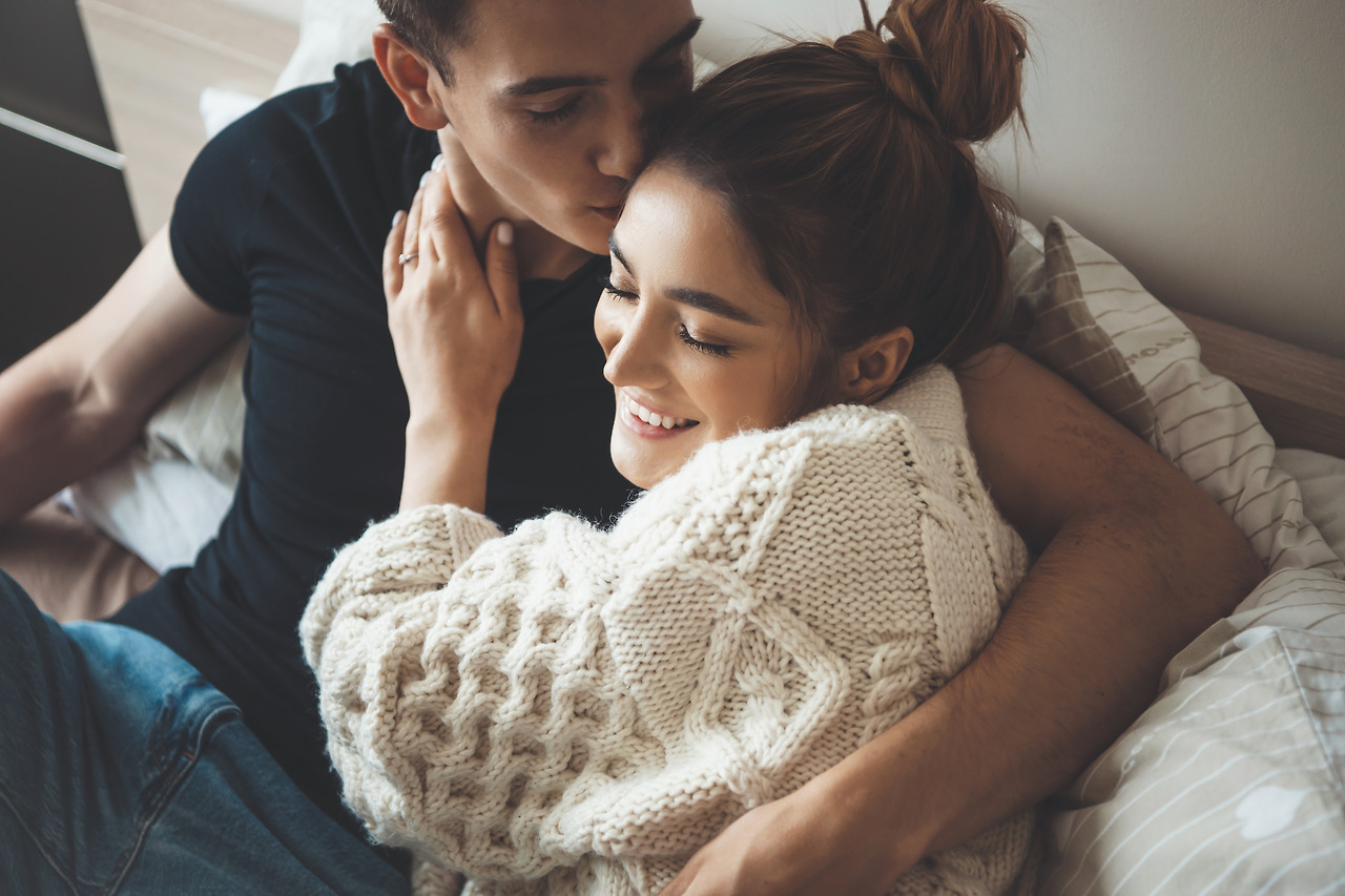 caucasian-man-kissing-his-cute-wife-dressed-white-knitted-sweater-embracing-bed.jpg