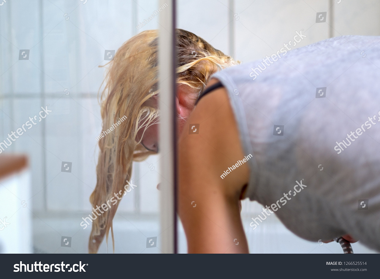 stock-photo-blond-woman-washing-her-hair-in-the-bathroom-viewed-through-a-glass-cubicle-as-she-bends-over-to-1266525514.jpg